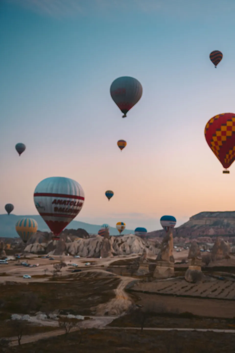 Hot air balloons drifting over the rock valleys of Cappadocia at sunrise