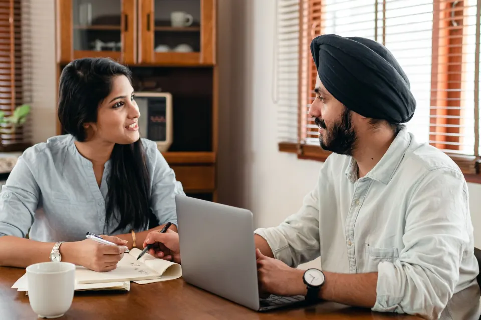 Two Indian colleagues reviewing work together on a laptop